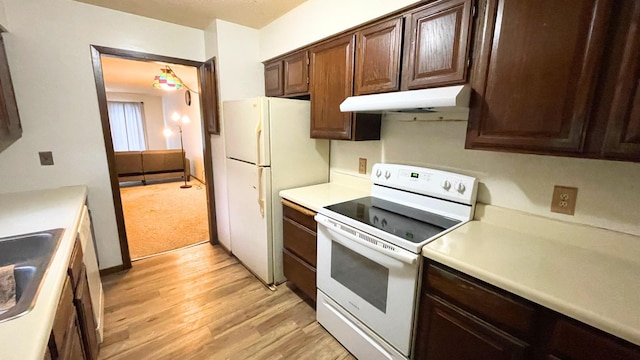 kitchen with sink, white appliances, and light wood-type flooring