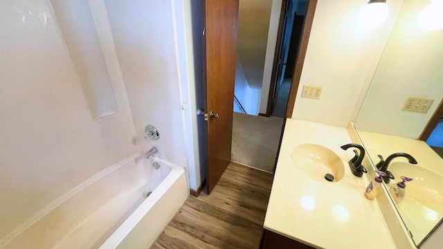 bathroom with vanity, hardwood / wood-style floors, and bathtub / shower combination