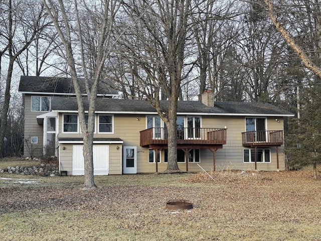 rear view of house with a deck and a garage