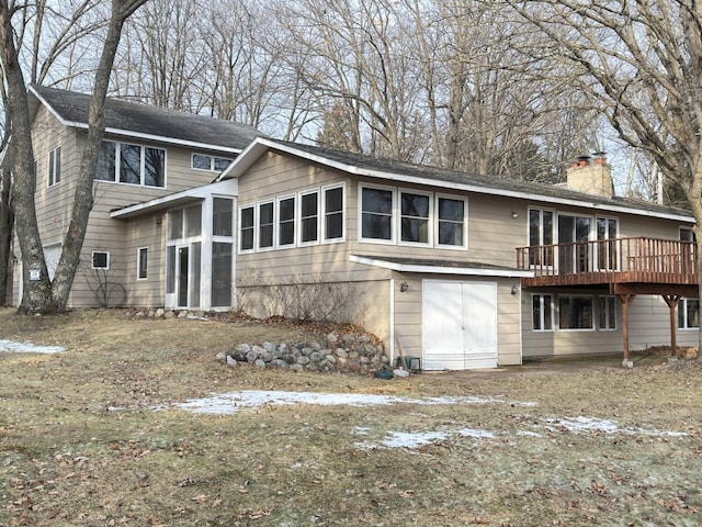 back of house with a wooden deck and a sunroom