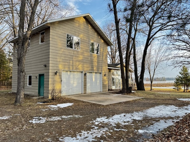 view of snowy exterior featuring a garage