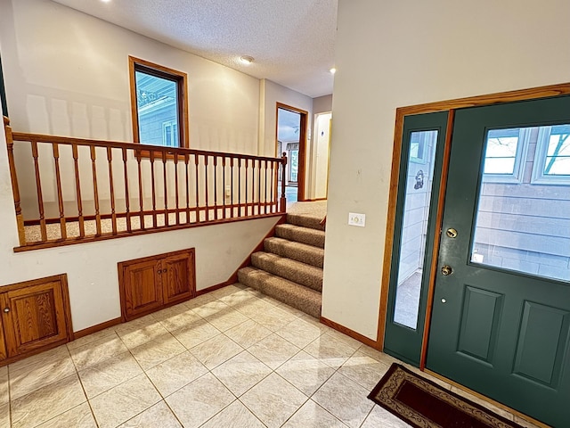 entryway featuring a textured ceiling and light tile patterned floors