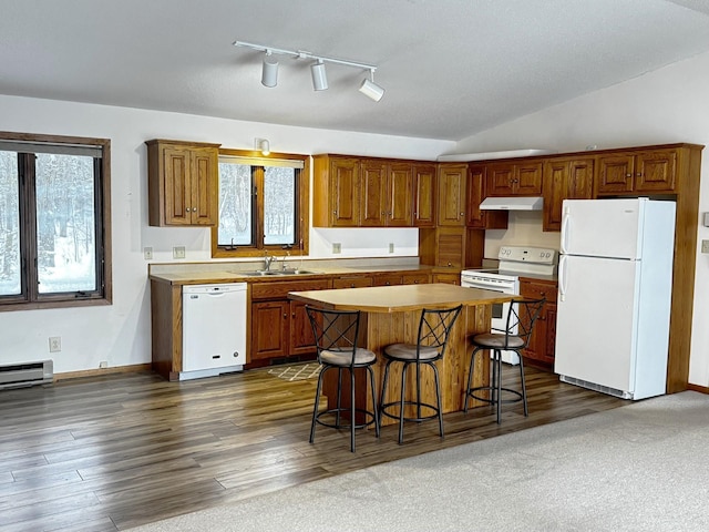 kitchen with sink, white appliances, a kitchen breakfast bar, a kitchen island, and dark hardwood / wood-style flooring