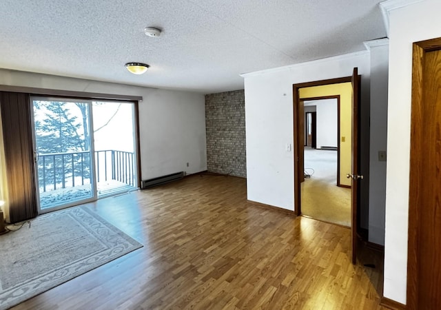 unfurnished room with a textured ceiling, a baseboard radiator, and hardwood / wood-style floors