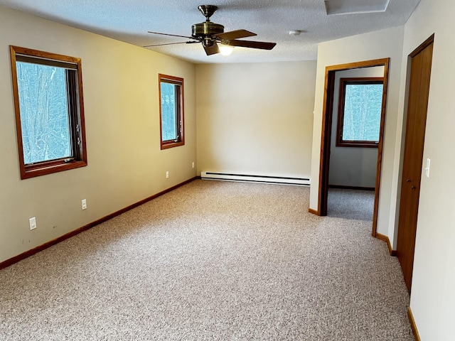 carpeted spare room with baseboard heating, a textured ceiling, and ceiling fan