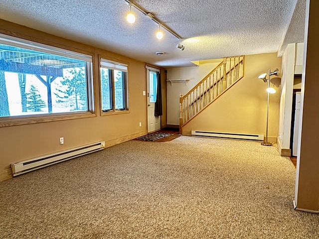 interior space with baseboard heating, a textured ceiling, and carpet