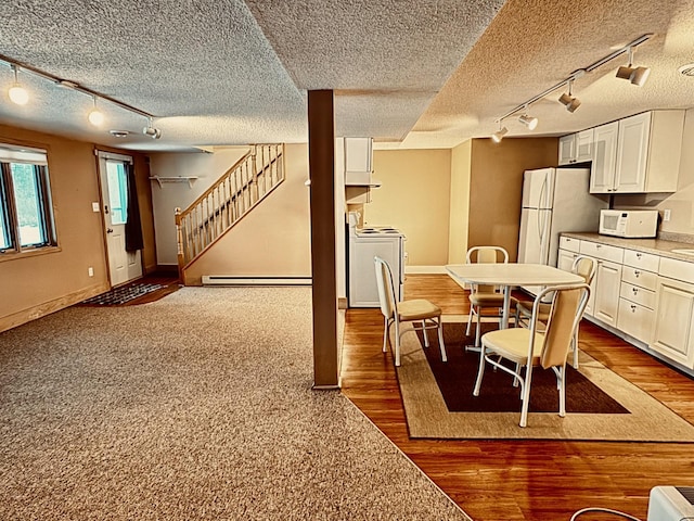 dining space with separate washer and dryer, dark hardwood / wood-style flooring, and a baseboard radiator