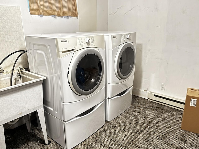 clothes washing area featuring baseboard heating and washer and dryer