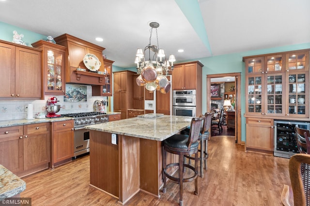 kitchen featuring hanging light fixtures, tasteful backsplash, an inviting chandelier, wine cooler, and appliances with stainless steel finishes