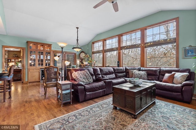 living room featuring hardwood / wood-style flooring, ceiling fan, and vaulted ceiling