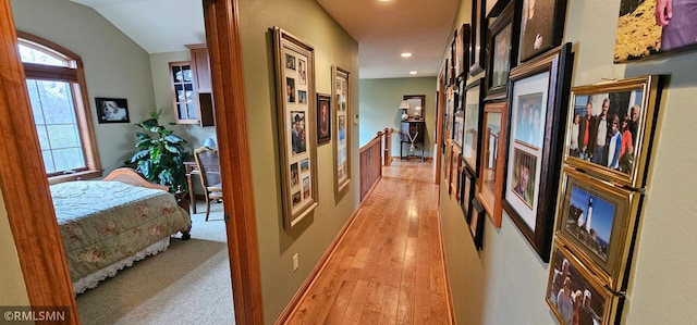 hallway featuring light hardwood / wood-style floors and vaulted ceiling