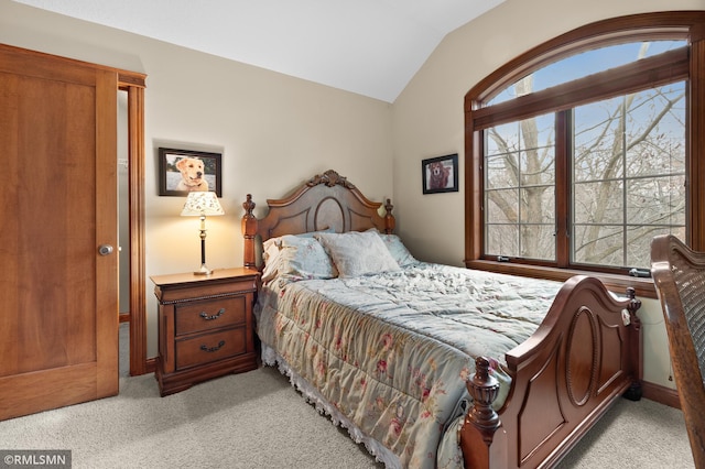 carpeted bedroom featuring vaulted ceiling and multiple windows