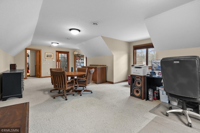 carpeted office featuring vaulted ceiling