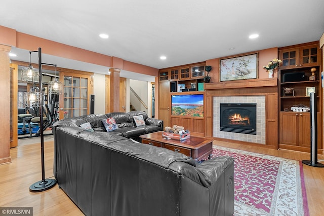 living room with a fireplace and light wood-type flooring