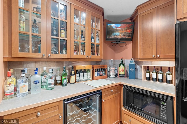 bar with backsplash, beverage cooler, and black appliances