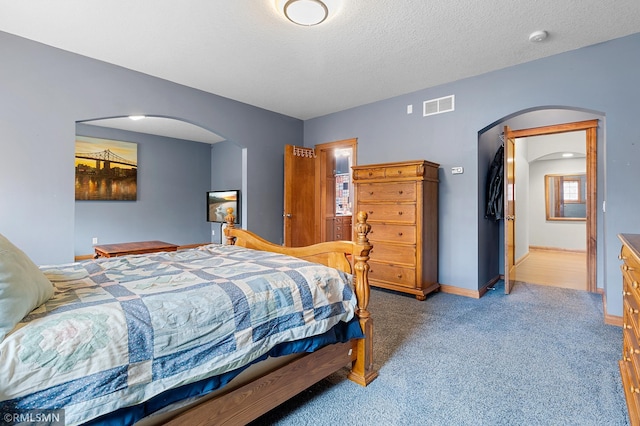 carpeted bedroom with a textured ceiling