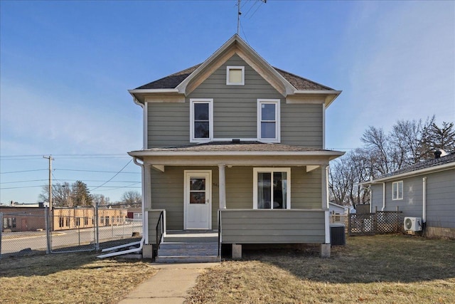 view of front property with cooling unit, a porch, and a front yard