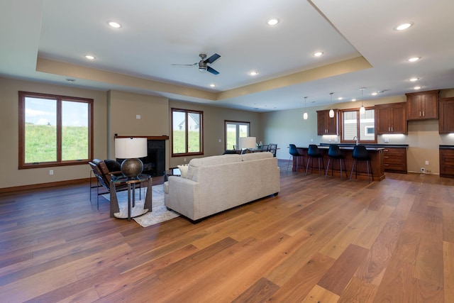 1018 Mahoe Way, Mankato, MN 56001 - living area with a raised ceiling, light wood-style flooring, recessed lighting, and ceiling fan