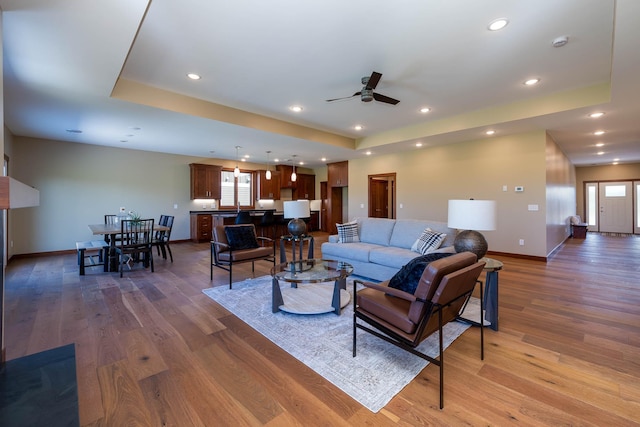 1018 Mahoe Way, Mankato, MN 56001 - living area featuring a tray ceiling, wood finished floors, ceiling fan, and recessed lighting