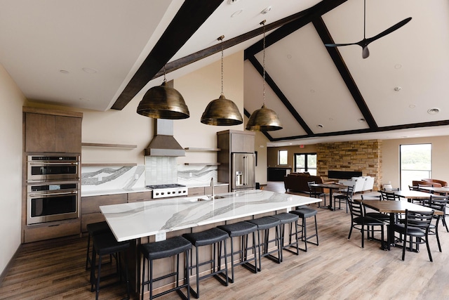 1018 Mahoe Way, Mankato, MN 56001 - kitchen with appliances with stainless steel finishes, modern cabinets, light wood finished floors, a kitchen bar, and beam ceiling