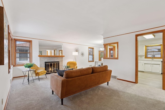 living room featuring light colored carpet and a brick fireplace