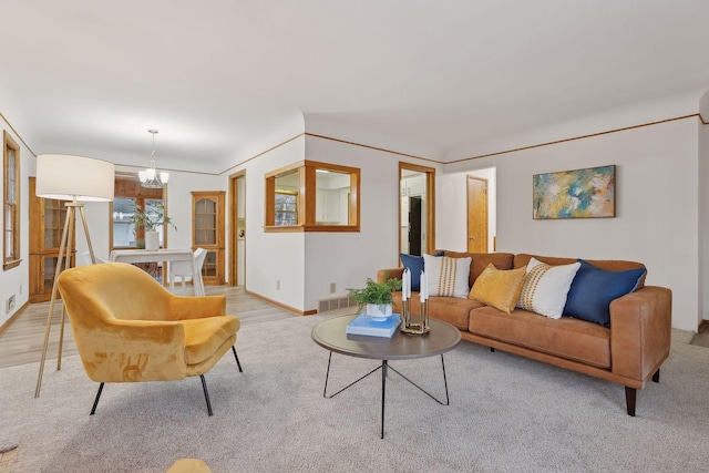 living room with light hardwood / wood-style flooring and an inviting chandelier