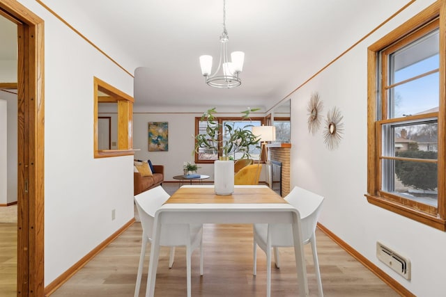 dining room featuring a chandelier, a wealth of natural light, and light hardwood / wood-style flooring