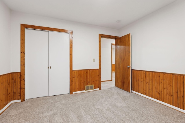 unfurnished bedroom featuring light colored carpet and a closet