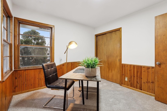 home office with wood walls and light colored carpet