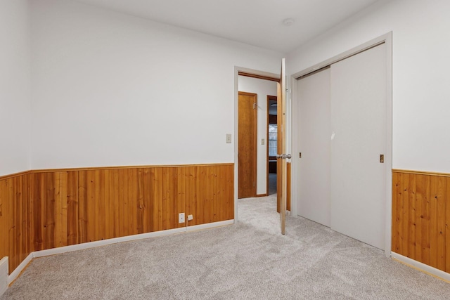 unfurnished bedroom featuring light colored carpet and a closet