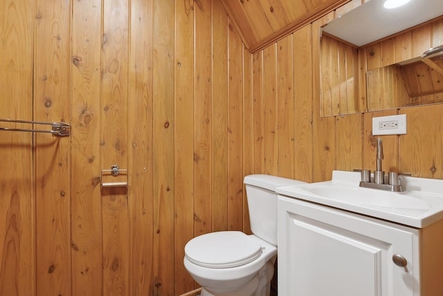 bathroom with vanity, vaulted ceiling, wooden ceiling, toilet, and wood walls