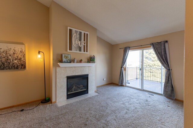 unfurnished living room featuring a tile fireplace, light colored carpet, and high vaulted ceiling