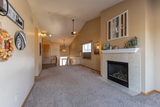 carpeted living room featuring ceiling fan, lofted ceiling, and a tile fireplace