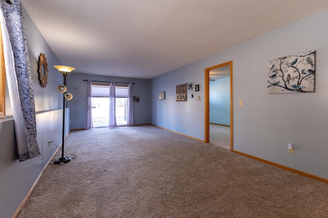 carpeted empty room featuring a textured ceiling