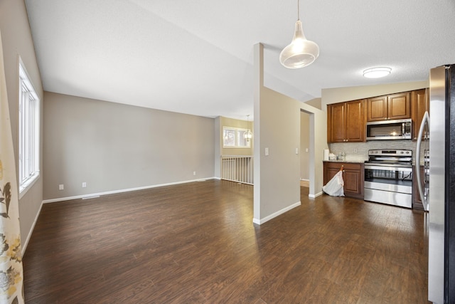 kitchen with vaulted ceiling, decorative light fixtures, tasteful backsplash, dark hardwood / wood-style flooring, and stainless steel appliances