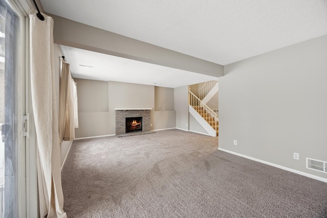 unfurnished living room with carpet flooring, a textured ceiling, and a fireplace