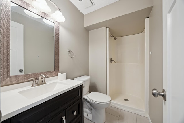 bathroom with tile patterned flooring, vanity, toilet, and a shower