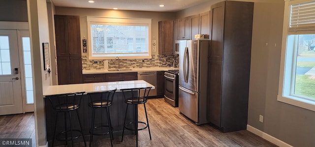 kitchen featuring backsplash, a kitchen breakfast bar, sink, a kitchen island, and stainless steel appliances