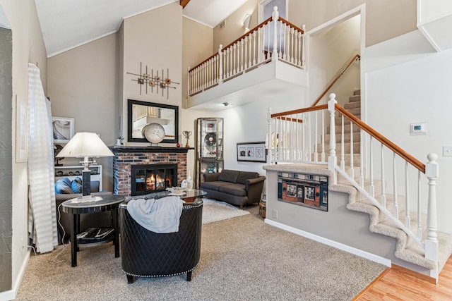 living room featuring hardwood / wood-style flooring, ornamental molding, a fireplace, and high vaulted ceiling