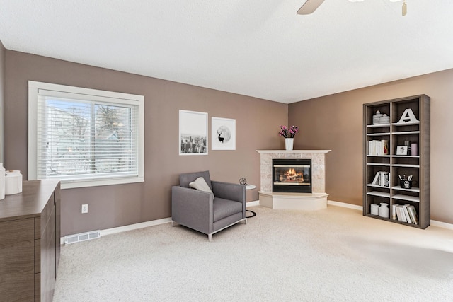 living area with carpet flooring and ceiling fan