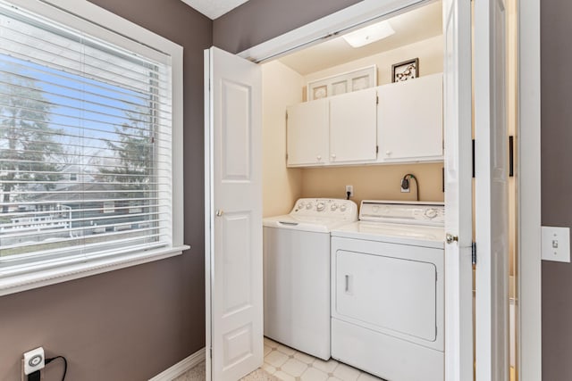 clothes washing area with cabinets and washing machine and dryer