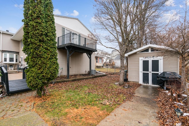 view of yard featuring a balcony and a storage shed