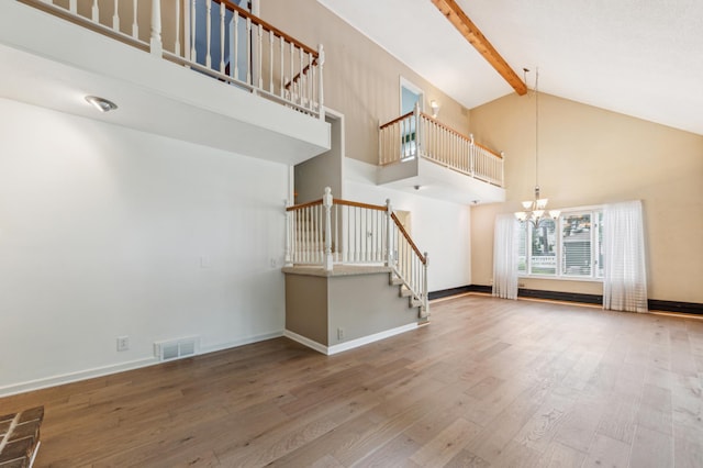 5945 Kellogg Ave, Edina, MN 55424 - unfurnished living room with high vaulted ceiling, stairway, a chandelier, wood finished floors, and beamed ceiling