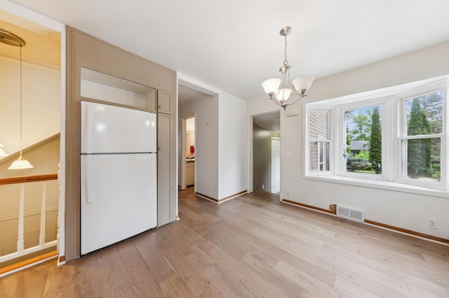 5945 Kellogg Ave, Edina, MN 55424 - unfurnished dining area featuring a chandelier, light wood-style floors, and baseboards