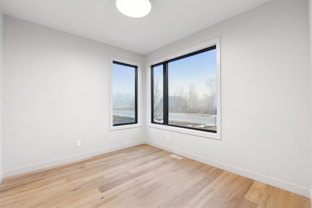 unfurnished room with visible vents, baseboards, and light wood-style floors