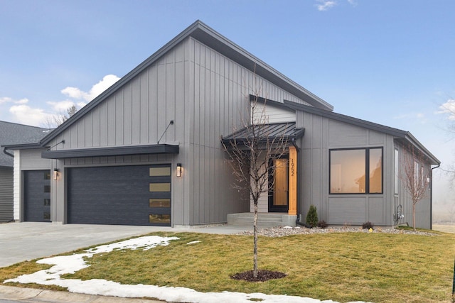 modern inspired farmhouse with a garage and a front lawn