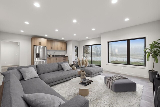 living room with a healthy amount of sunlight, bar area, and light hardwood / wood-style flooring