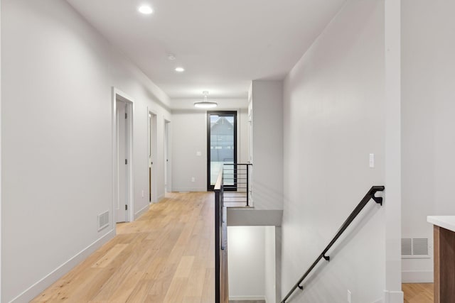 hall featuring baseboards, visible vents, recessed lighting, an upstairs landing, and light wood-type flooring