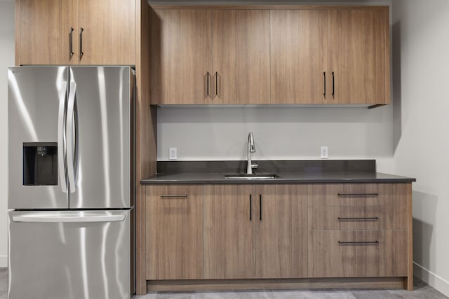 kitchen featuring a sink, modern cabinets, and stainless steel fridge with ice dispenser