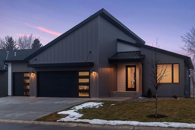 modern farmhouse style home with a standing seam roof, concrete driveway, a garage, a lawn, and metal roof